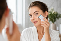 Woman using the Cirenna microcurrent facial device on her cheek